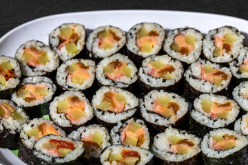 Top view of stack of Japanese sushi maki roll plate. Served in Japanese bar restaurant with chopstick