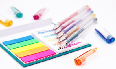 Naklejka premium Various colored pencils, paper, notes on white background.