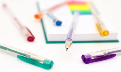 Various colored pencils, paper, notes on white background.