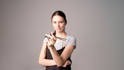 Attractive hairdresser woman with professional tools in her hands