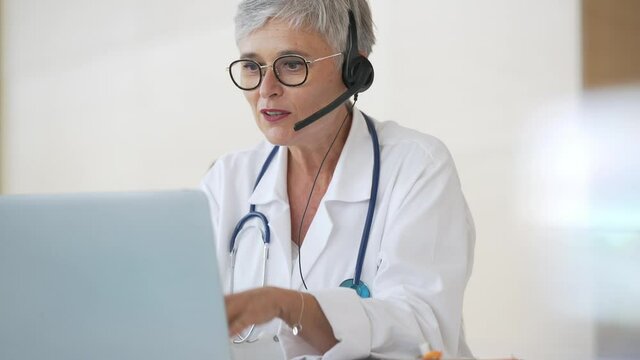 Practitioner in office having virtual consultation online with patient