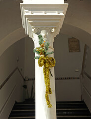 columna de mármol blanco con adornos de Navidad en un patio de Sevilla, España