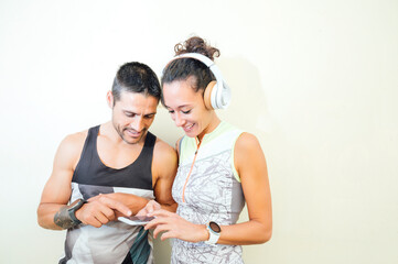 Fototapeta premium young couple of runners looking at the mobile in during a break
