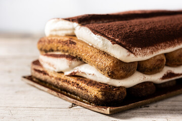 Traditional tiramisu cake on wooden table