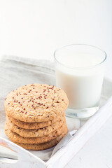 Healthy oatmeal and red quinoa cookies on white tray, served with milk, vertical, copy space