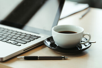 Laptop and cup of coffee on old wooden table,for background