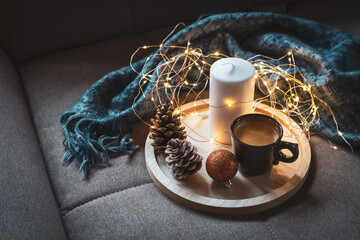 Eine Tasse Kaffee, eine Kerze und eine Lichterkette auf einem Holz Serviertablett auf einem braunen...
