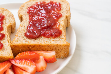 whole wheat bread with strawberry jam and fresh strawberry