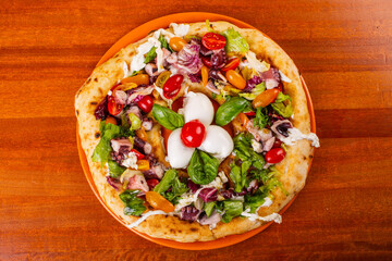 Pizza napoletana con polpo, pomodori rossi, pomodori gialli, insalata, basilico e con tre bocconcini di mozzarella di bufala al centro 
