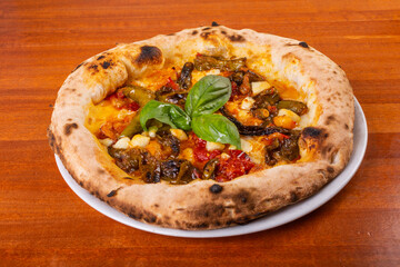 Pizza napoletana con melanzane, peperoni, mozzarella, pomodori e basilico fresco