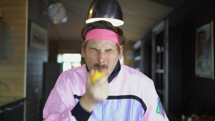 A freaky guy eats a whole lemon on a bet, the guy eats a lemon and grimaces because he is sour, a close-up portrait of an unusual freak who makes a challenge for social networks.