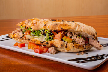 Saltimbocca con pasta per la pizza ripieno di tonno, pomodori, scarola e aceto balsamico