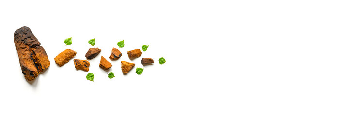 peeled piece of birch chaga mushroom and crushed chaga fungus pieces for tea brewing isolated on a white background. banner. space for text