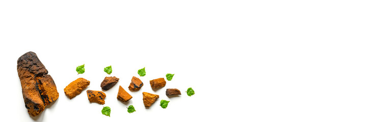 peeled piece of birch chaga mushroom and crushed chaga fungus pieces for tea brewing isolated on a white background. banner. space for text
