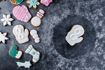 Various christmas gingerbread cookies on dark table with flour
