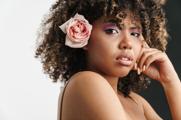 Beautiful sensual african american girl with rose posing at camera