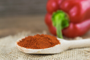 Natural, organic red pepper on wooden background with 
spice on a spoon