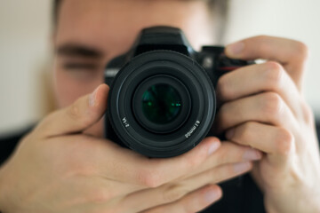 close-up of a boy taking a picture with a professional camera. Concept of photography, hobby, business.