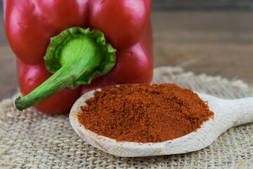 Natural, organic red pepper on wooden background with 
spice on a spoon