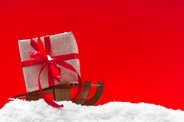 Festive red Christmas and snow background with christmas gift and ribbon