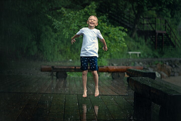 Fototapeta na wymiar Child playing in heavy rain outside