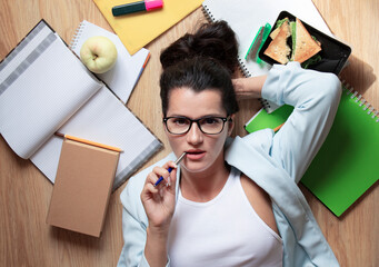 
Business woman with glasses working on a project and holding a pen in her mouth