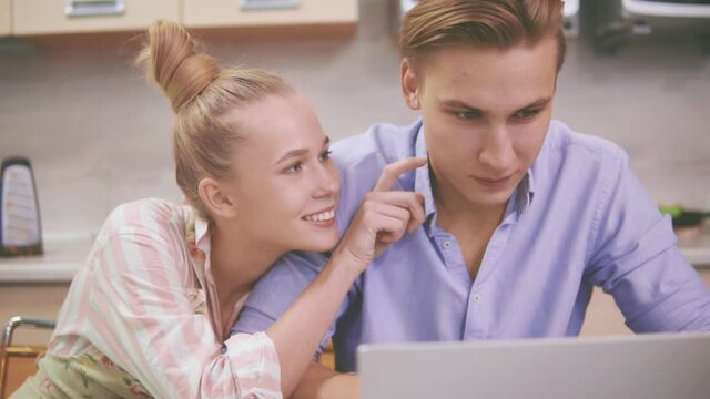 A woman harasses her husband,&nbsp;who&nbsp;works at a laptop