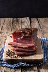 Dried and smoked meat on wooden table. 