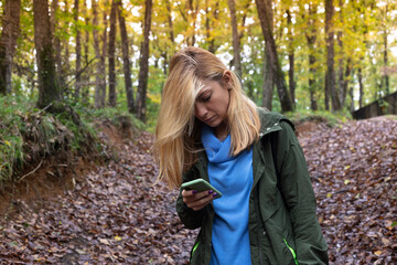 Beautiful woman using with smart phone in the forest