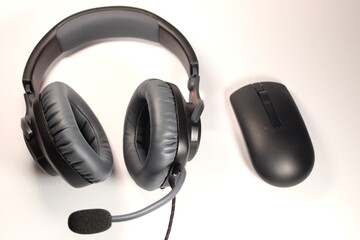 Over ear headset and wireless mouse isolated on white background.
