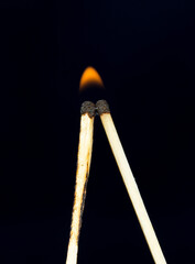 two matchstick lit on black background