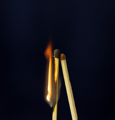 two matchstick lit on black background