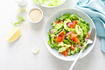 Salmon avocado salad with salted fish, lettuce, red onion and cucumbers