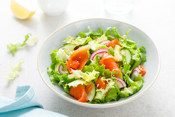 Salmon avocado salad with salted fish, lettuce, red onion and cucumbers