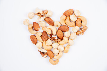 Various nuts in the shape of a heart on a white background.