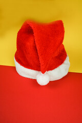 Obraz na płótnie Canvas Santa hat on yellow-red background with copy space. Christmas shopping concept