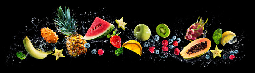 Assortment of fresh fruits and water splashes on panoramic background
