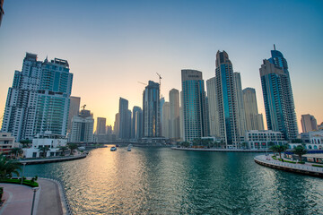Fototapeta premium DUBAI, UAE - DECEMBER 6, 2016: Dubai Marina at sunset. Skyscrapers along the canals