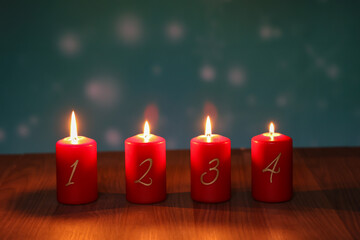 Fototapeta na wymiar Red Advent candles stand on a wooden floor