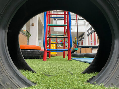 indoors playground for children with synthetic green grass and colorful