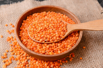 Bowl and spoon with raw lentils on table