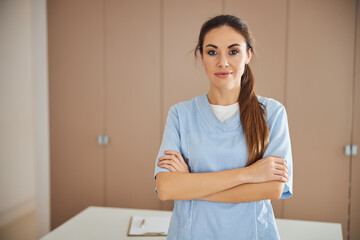 Young beautiful lady in medical uniform posing at office