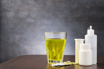 Glass with medicine and jars with pill and tablet