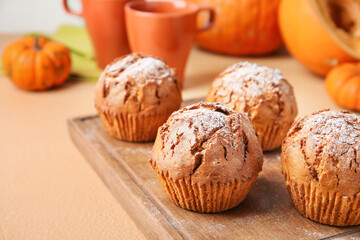 Board with tasty pumpkin muffins on table