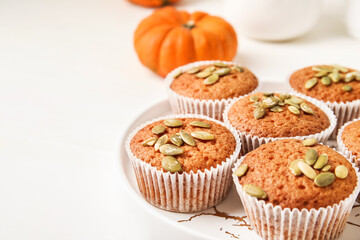 Plate with tasty pumpkin muffins on table, closeup