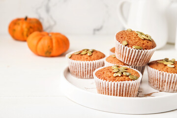 Plate with tasty pumpkin muffins on table