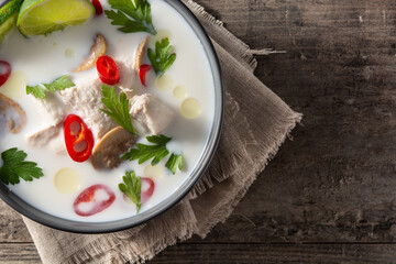 Traditional Thai food Tom Kha Gai in bowl on wooden table.Top view. Copy space	
