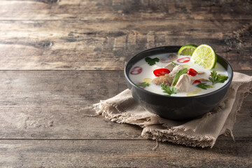 Traditional Thai food Tom Kha Gai in bowl on wooden table.Copy space	