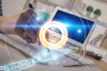 Cryptocurrency hologram, bitcoin, ico theme over hands taking notes background. Concept of blockchain. Multi exposure