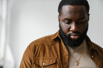 Handsome african american man posing and looking downward indoors